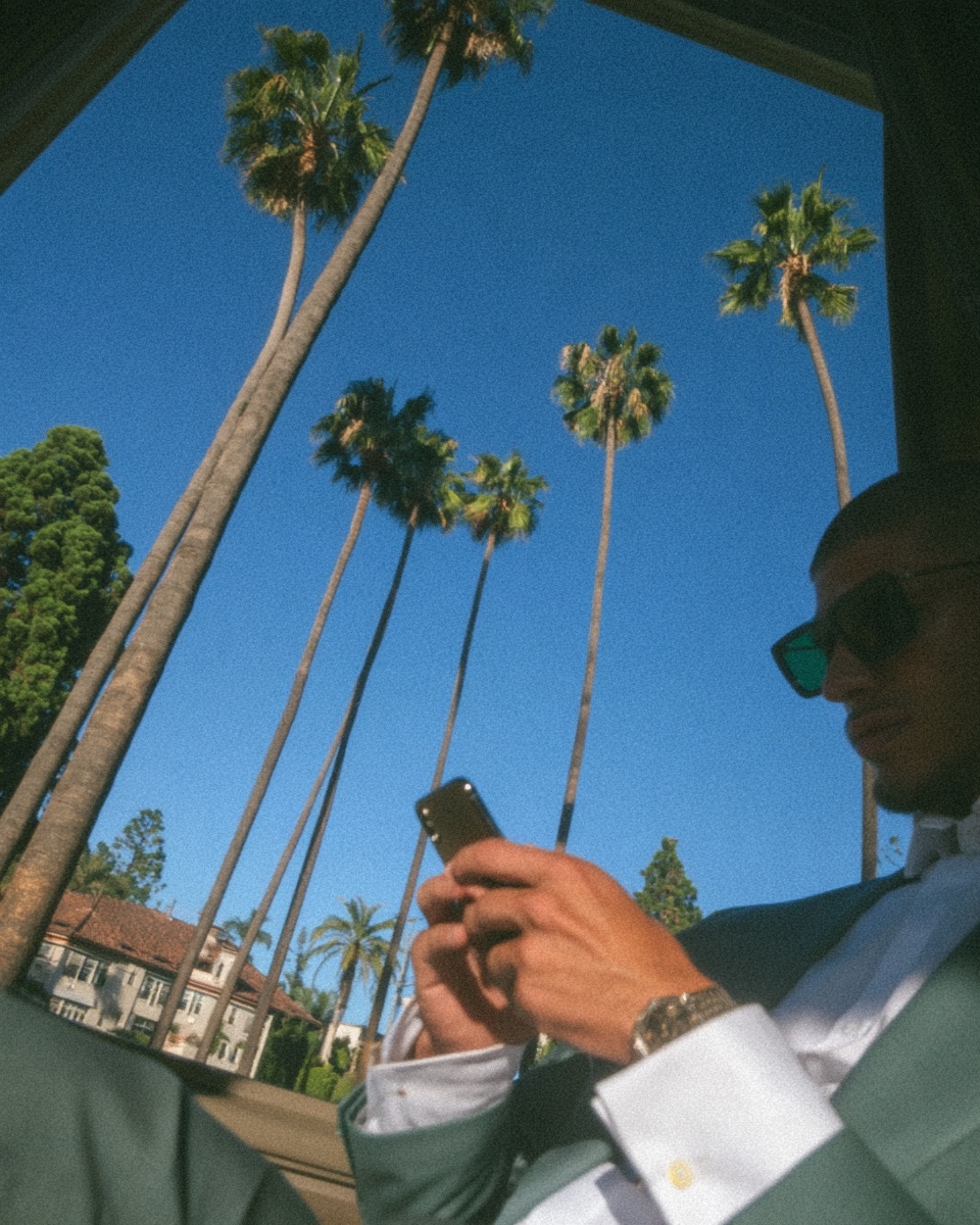A leader checking a phone beneath palm trees